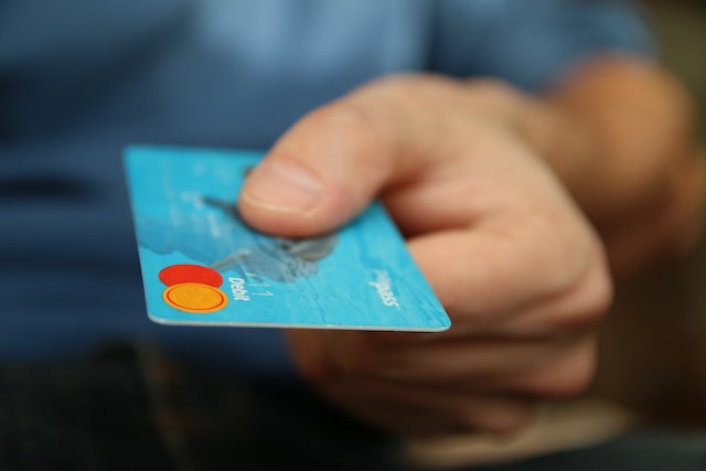 hand holding a blue credit card